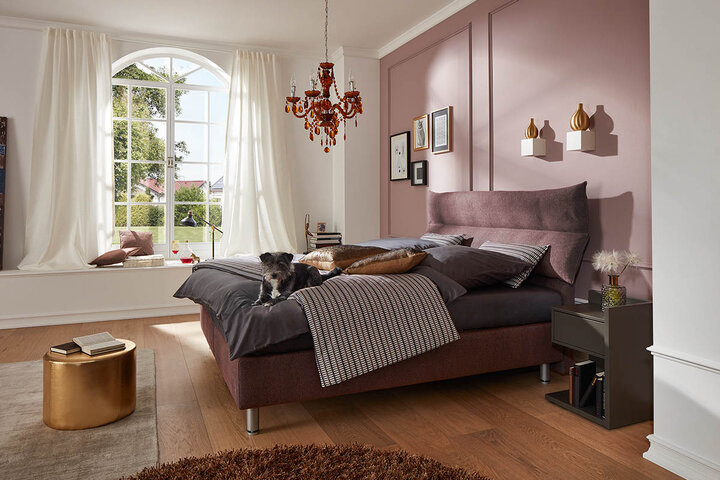 Minimalistisches RUF Bett mit geradlinigem Design, hellem Stoffbezug und stilvoller Beleuchtung im Schlafzimmer.