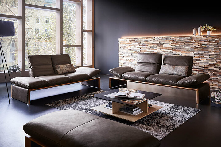KOINOR-Designsessel mit passendem Hocker in anthrazitfarbenem Leder – drehbar, ergonomisch und ideal für stilvolle Entspannung.