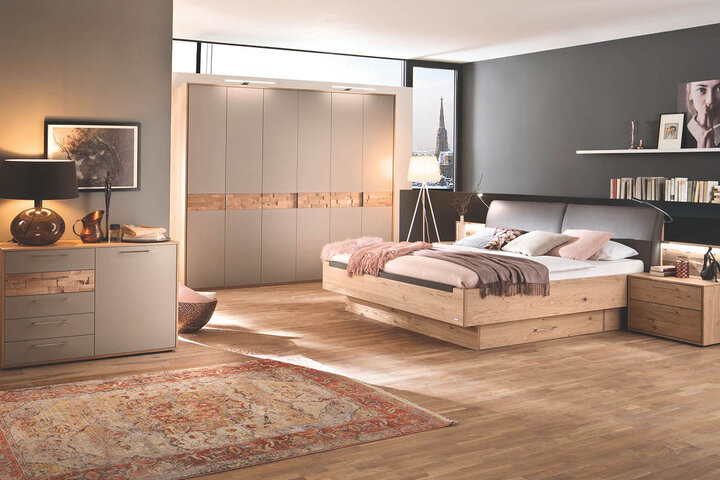 Schlafzimmer von Casada mit Eichenholz-Bettgestell, Lederrückenlehne und weichen Kissen.