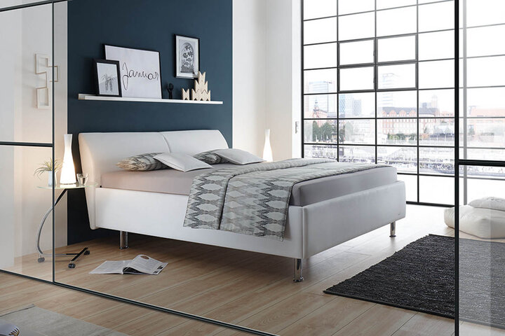 RUF Bett mit stilvollem Polsterkopfteil, stimmigem Farbkonzept und dekorativem Hintergrund im Schlafzimmer.