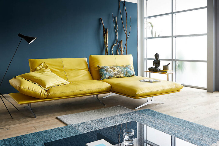 Wohnlandschaft von KOINOR in hellem Stoffbezug mit organischer Linienführung – kombiniert mit modernem Interieur und natürlicher Lichtführung.