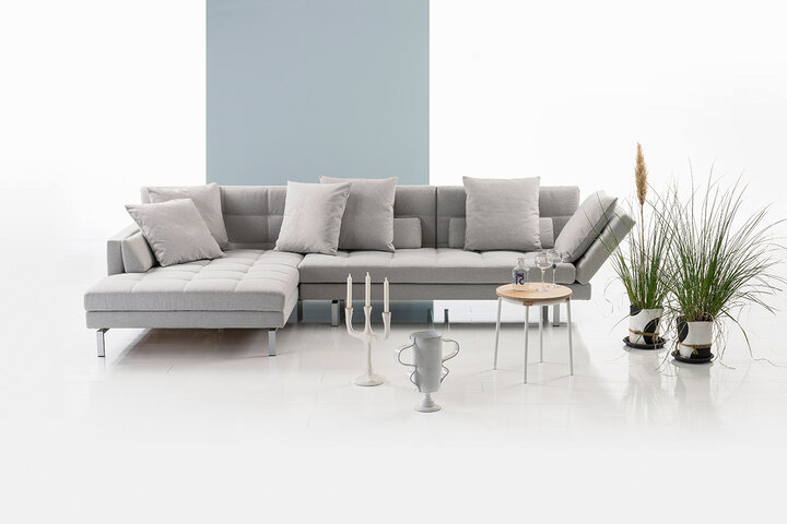 Hellgraues Ecksofa von brühl mit klarer Linienführung, Rückenlehne und Kissen.