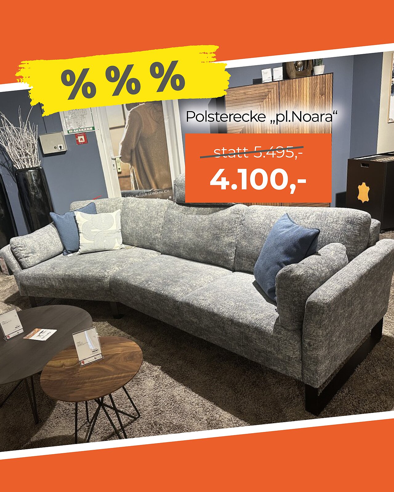 Graues Ecksofa mit zwei blauen und einem hellgrauen Kissen